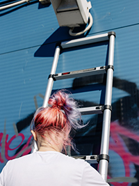 une fille grimpe sur une échelle télescopique de 3,8 m pour peindre